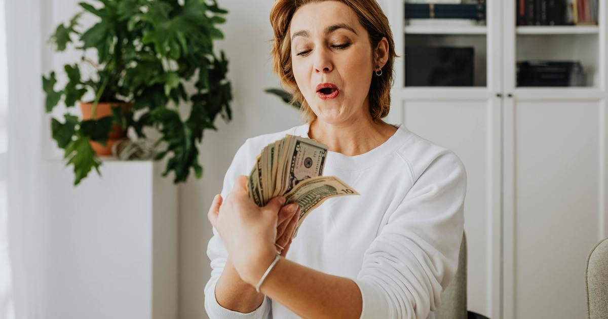 Writer smiling holding money