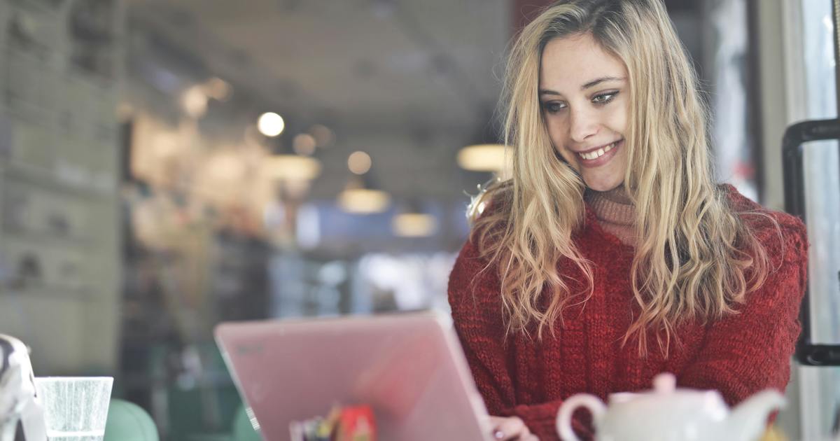 Writer smiling typing on a laptop