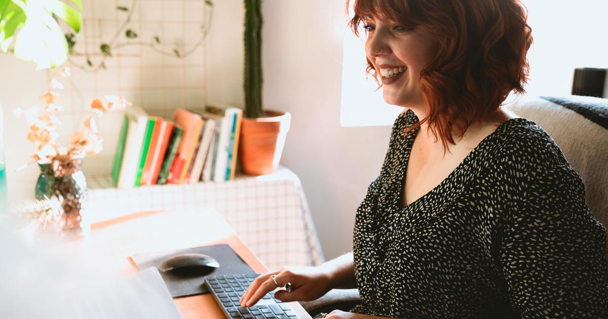 Writer sitting at desk typing on laptop
