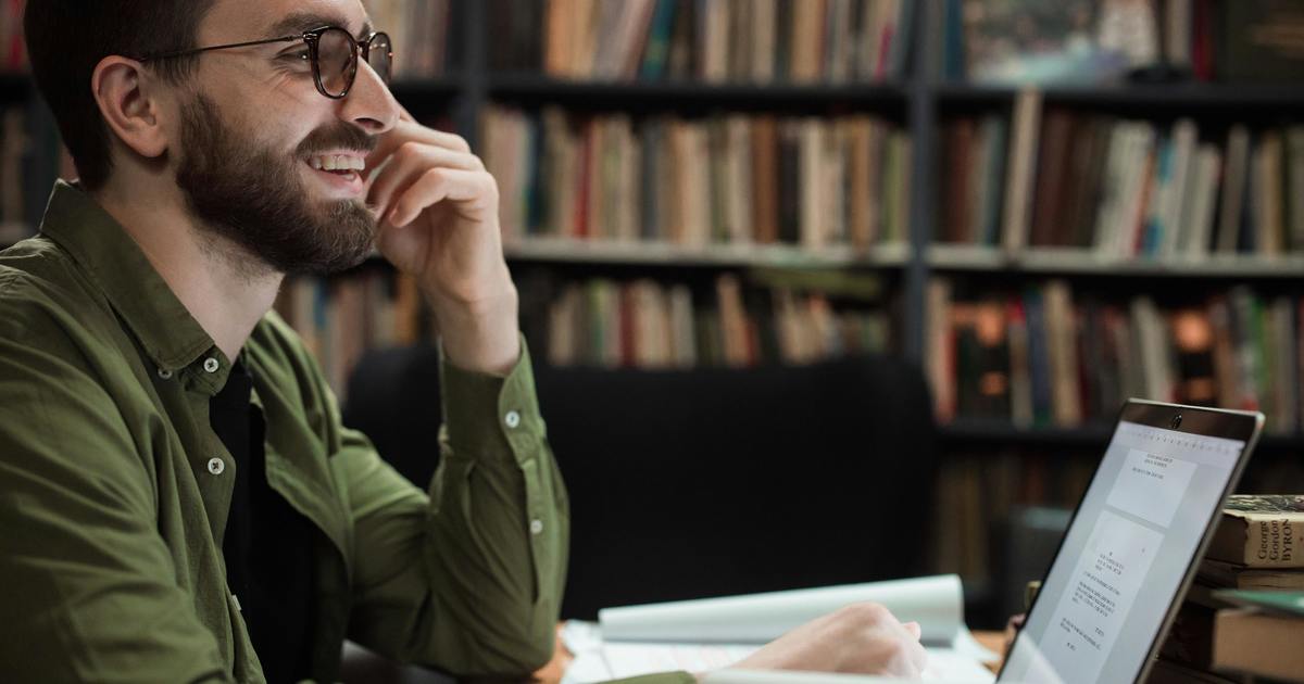 Writer sitting at desk typing on laptop